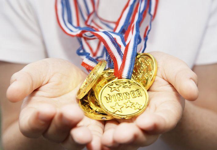 Medale zwycięscy trzymane w dłoniach